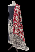 A long draped scarf with a split design, featuring a solid navy blue panel on one side and a red, cream, and black floral block-print pattern on the other, displayed on a mannequin against a black background.